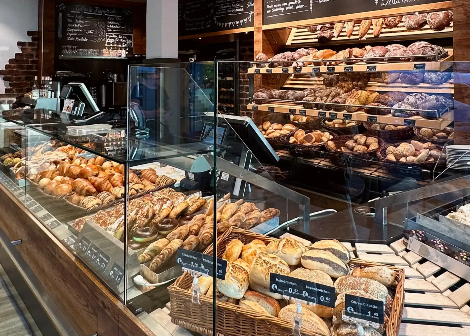 Verkaufstheke mit Gebäck und Brötchenkörben vor dem Brotregal in der Bäckerei Storch in Petersberg