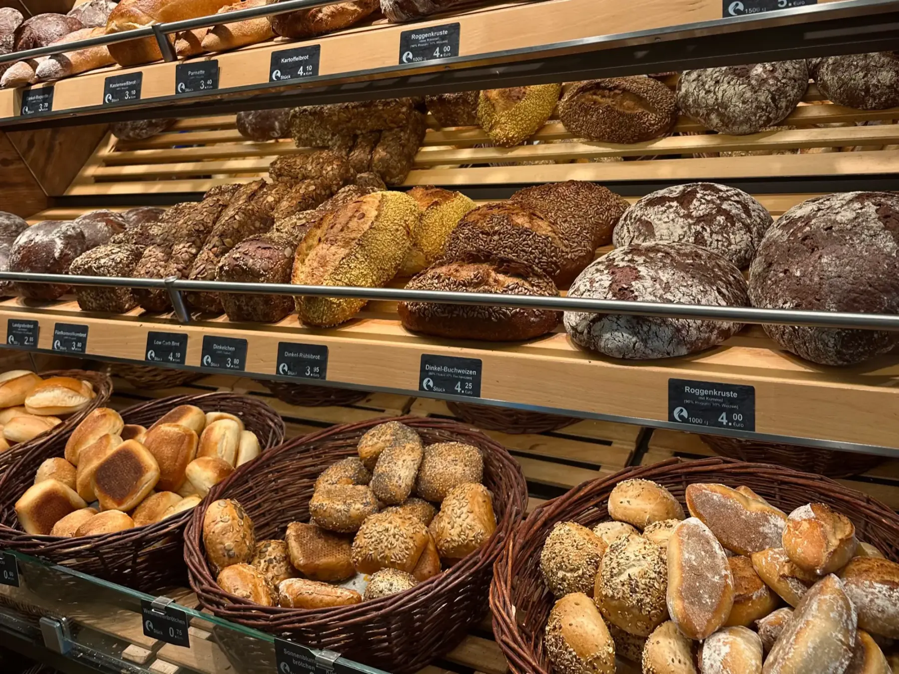 Brotregal mit Brotlaiben und Körben voller Brötchen in der Bäckerei Storch in Petersberg