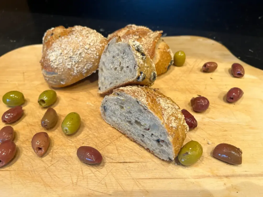 Aufgeschnittenes Olivenbrot mit grünen und dunklen Oliven
