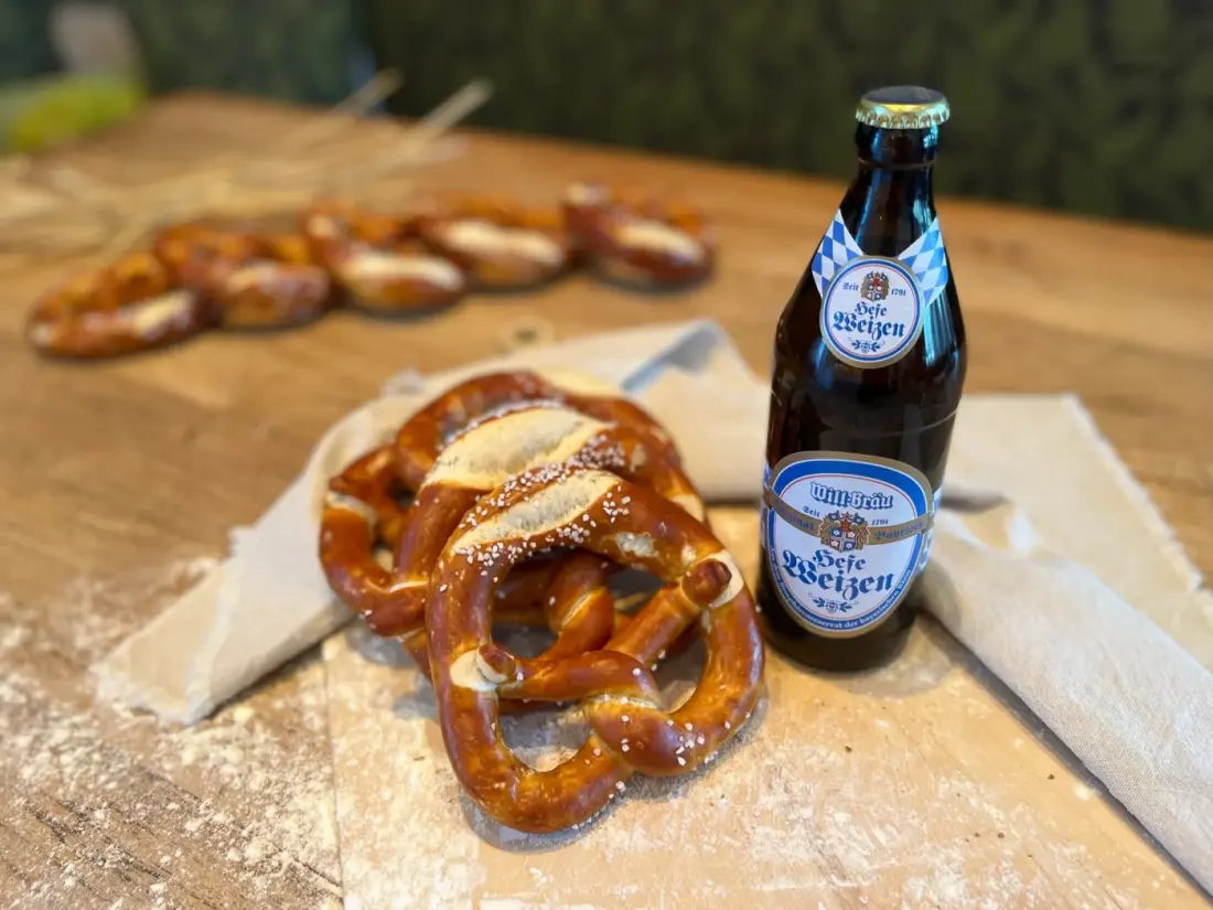 Frisch gebackene Brezeln mit einer Flasche Weißbier